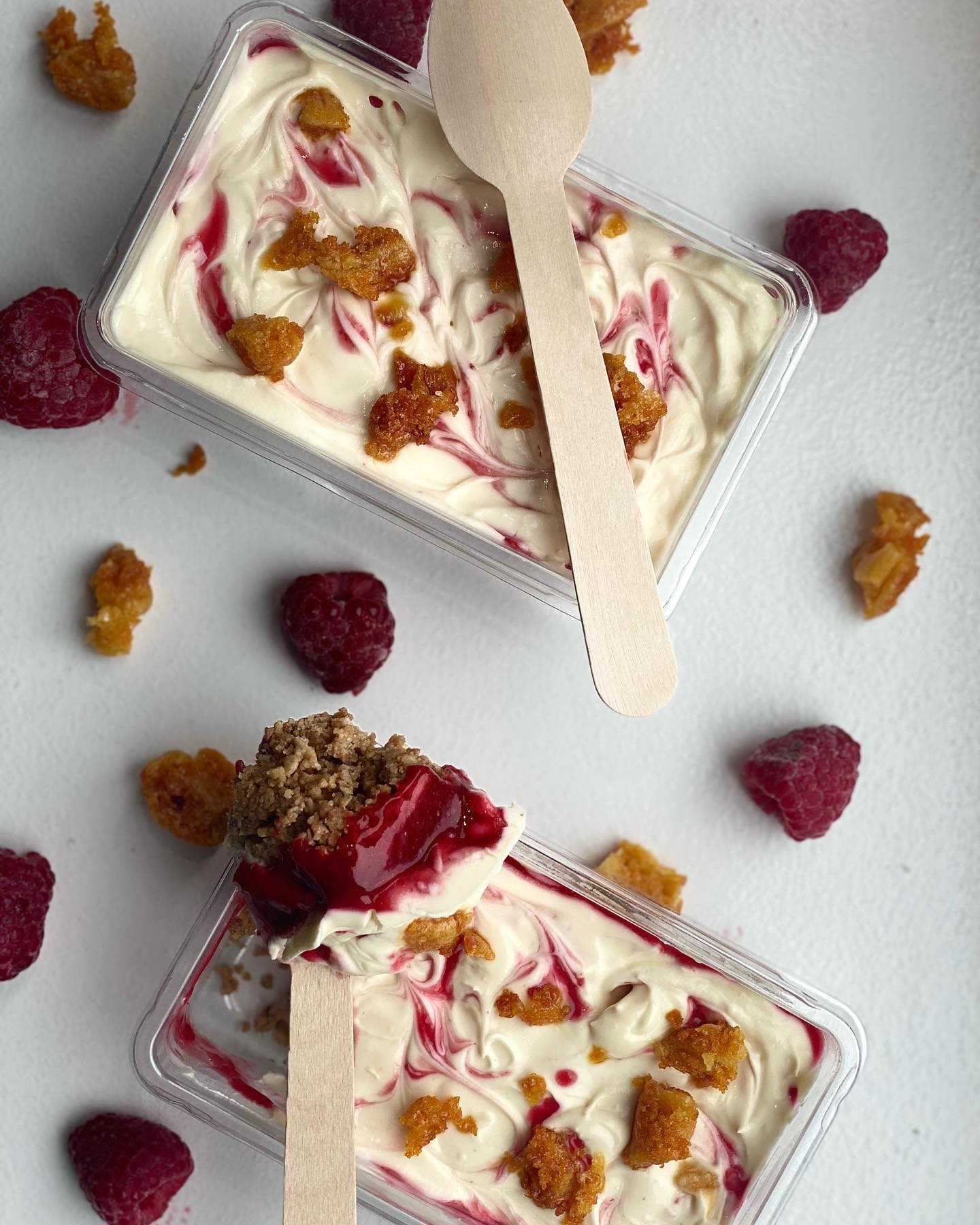 Raspberry ripple dessert with crushed honeycomb in a clear tub