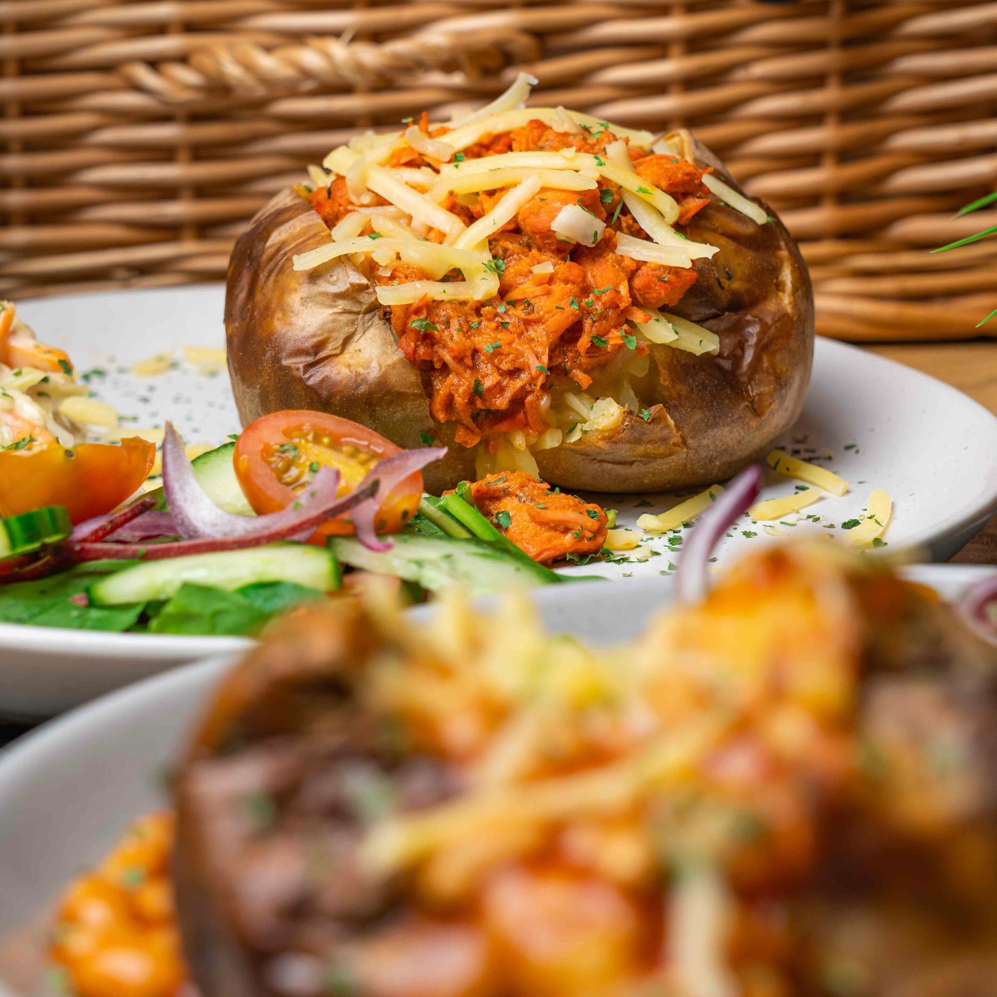 Loaded baked potato — slow-baked jacket potato topped with pulled chicken, melted cheese and herbs, with a side salad